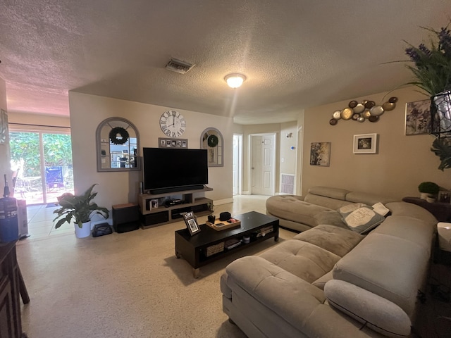 living area featuring visible vents and a textured ceiling