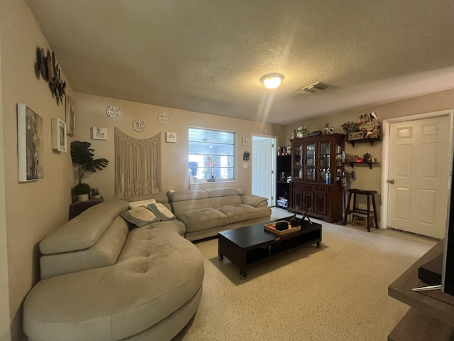 carpeted living room featuring a textured ceiling and visible vents