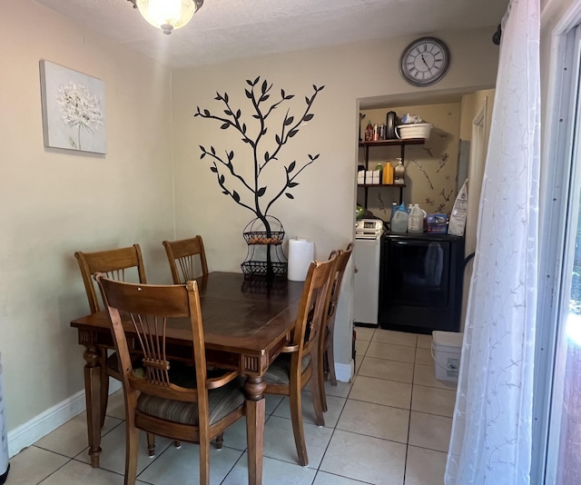 dining room with washer / clothes dryer, light tile patterned floors, and baseboards
