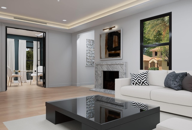 living area featuring a premium fireplace, light wood-type flooring, baseboards, and recessed lighting