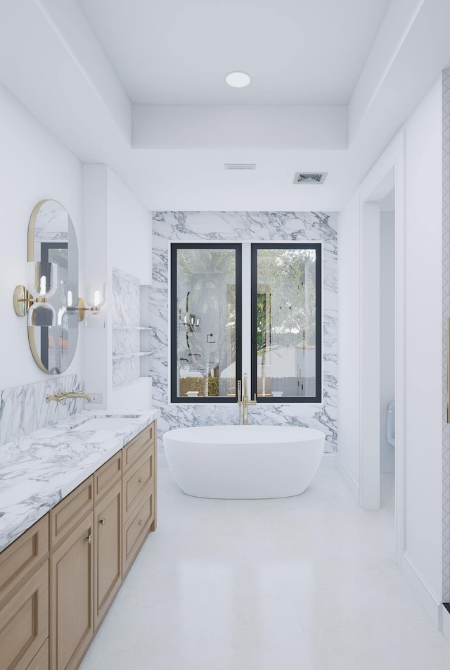 bathroom featuring a chandelier, a freestanding tub, vanity, and visible vents