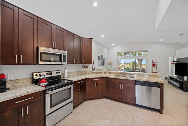 kitchen with a sink, stainless steel appliances, light tile patterned floors, a peninsula, and lofted ceiling