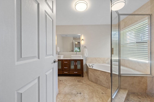 full bathroom with double vanity, a tile shower, a bath, and a sink