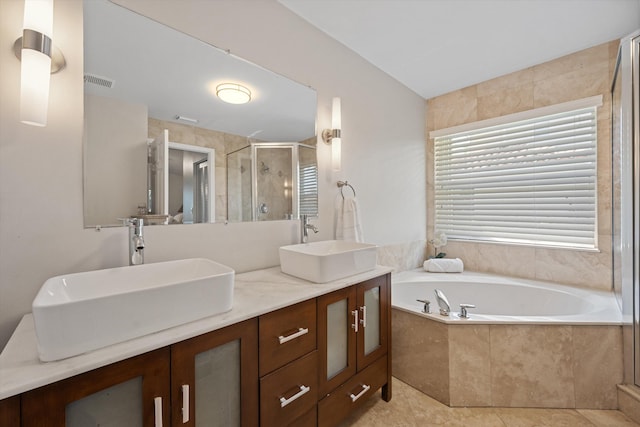 full bath with double vanity, a garden tub, a stall shower, and a sink