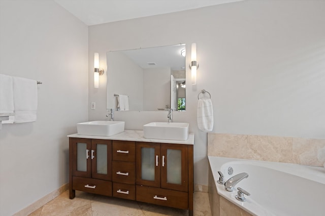 bathroom featuring double vanity, a garden tub, baseboards, and a sink