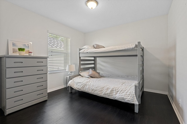 bedroom with dark wood-style floors and baseboards