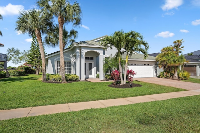 view of front of property featuring an attached garage, driveway, stucco siding, and french doors