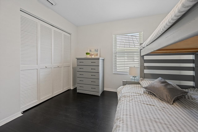 bedroom featuring baseboards, wood finished floors, and a closet