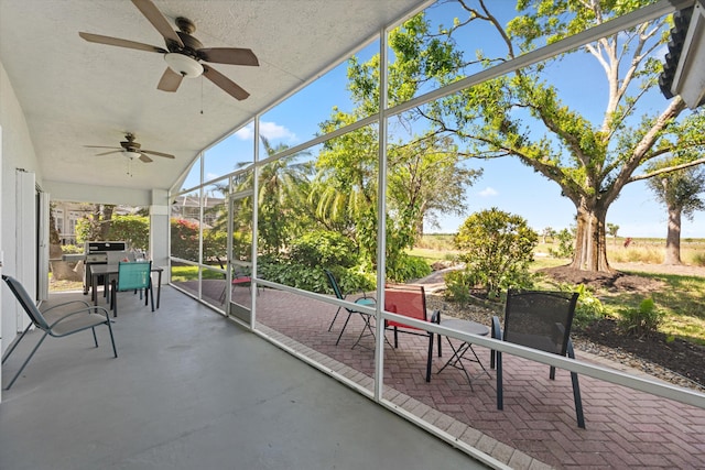 sunroom / solarium featuring ceiling fan and outdoor dining space