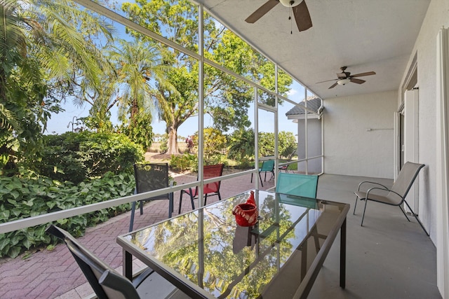 balcony with outdoor dining space, a patio, and ceiling fan