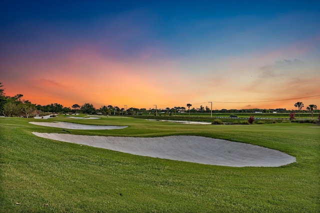 view of home's community featuring a lawn and view of golf course