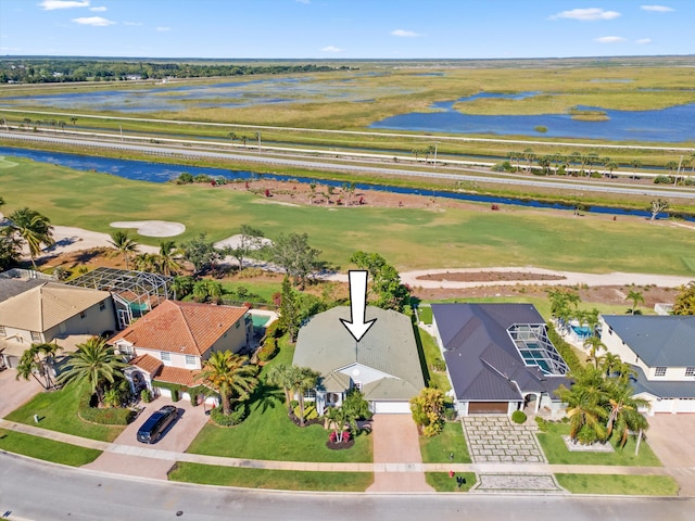 bird's eye view with golf course view, a water view, and a residential view