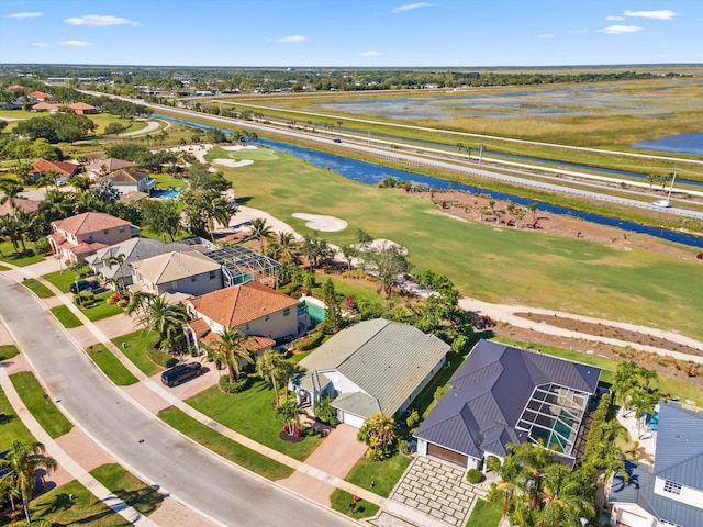 bird's eye view with a water view, a residential view, and view of golf course