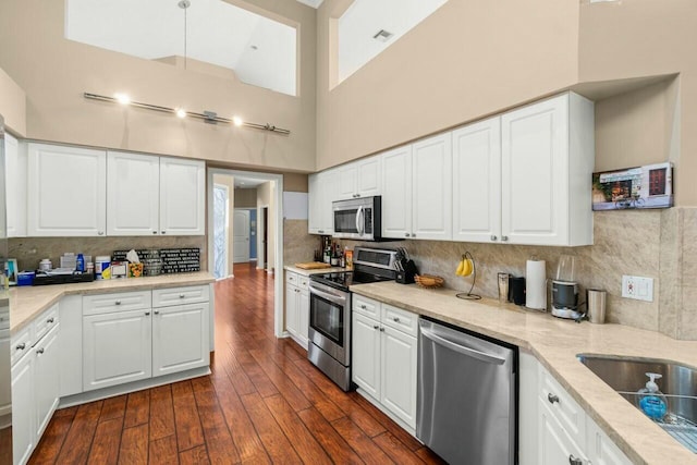 2476 NW 67th St, Boca Raton, FL 33496 - kitchen featuring white cabinetry, a high ceiling, dark wood finished floors, and stainless steel appliances