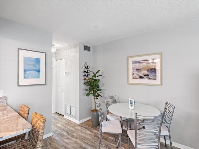 2800 Indian River Blvd Unit F8, Vero Beach, FL 32960 - dining space with wood finished floors and a textured ceiling
