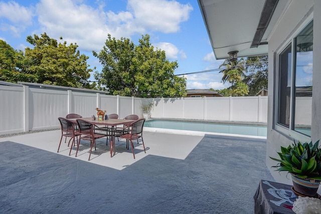 view of patio / terrace with a fenced backyard, a fenced in pool, and outdoor dining space