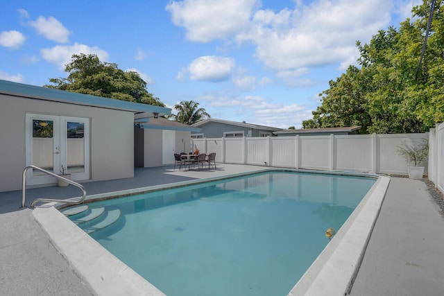 view of swimming pool with a fenced in pool, a patio area, fence, and french doors