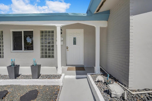 view of exterior entry featuring covered porch