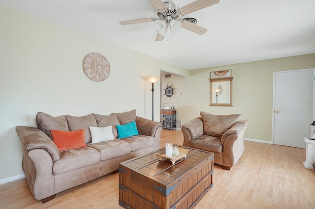 living room featuring light wood-style floors, baseboards, ceiling fan, and visible vents
