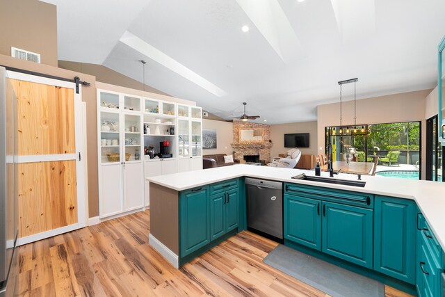 kitchen with a fireplace, light wood-type flooring, a sink, and dishwasher