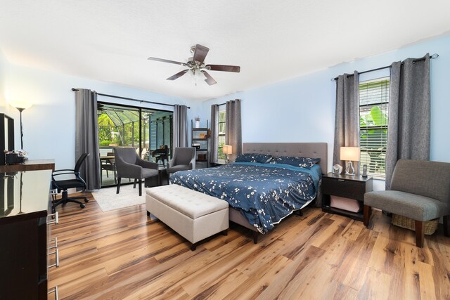 bedroom featuring ceiling fan, wood finished floors, and multiple windows