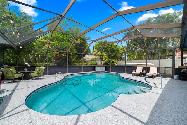 view of swimming pool featuring a fenced in pool, glass enclosure, a patio area, and fence
