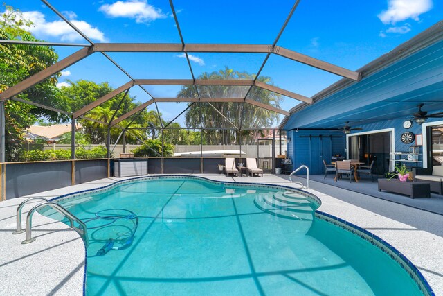 pool with a ceiling fan, glass enclosure, and a patio area