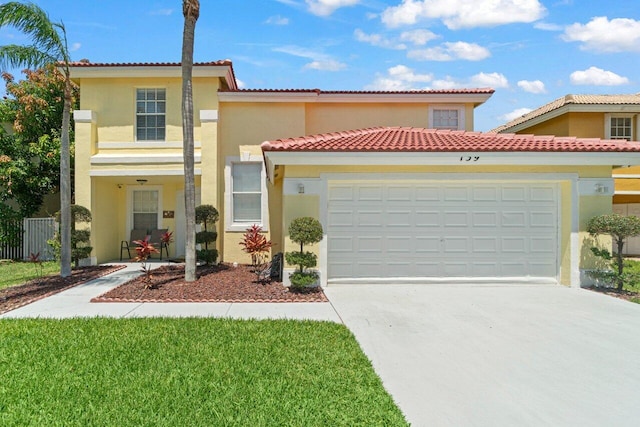 mediterranean / spanish home featuring an attached garage, a tile roof, concrete driveway, and stucco siding