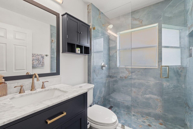 full bath with vanity, a shower stall, and toilet