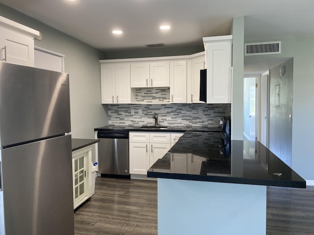 563 Capri L, Delray Beach, FL 33484 - kitchen featuring appliances with stainless steel finishes, dark countertops, dark wood finished floors, recessed lighting, and white cabinetry