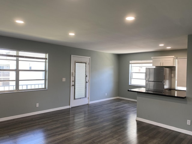563 Capri L, Delray Beach, FL 33484 - kitchen featuring freestanding refrigerator, white cabinetry, dark countertops, dark wood-style flooring, and recessed lighting