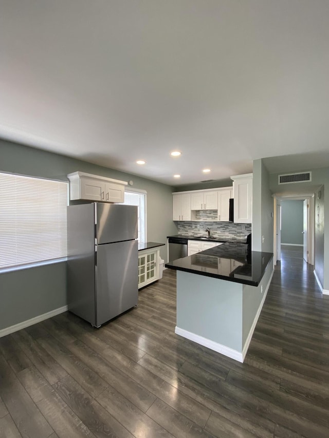 563 Capri L, Delray Beach, FL 33484 - kitchen featuring freestanding refrigerator, dark countertops, white cabinets, a peninsula, and recessed lighting
