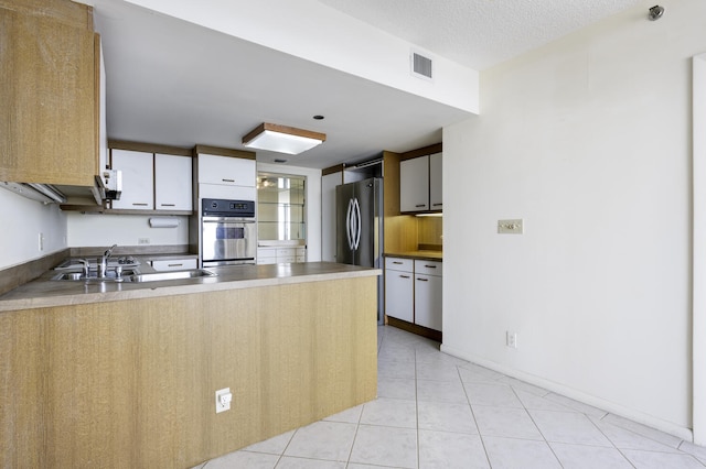 529 S Flagler Dr Unit 25F, West Palm Beach, FL 33401 - kitchen featuring light tile patterned floors, a peninsula, visible vents, a sink, and stainless steel appliances