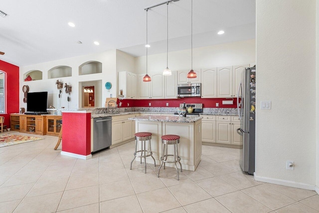 kitchen with visible vents, a sink, a kitchen island, appliances with stainless steel finishes, and a breakfast bar area