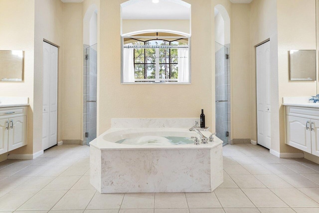bathroom featuring tile patterned flooring, vanity, and a stall shower
