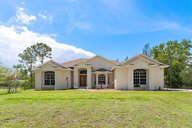 view of front of property featuring french doors, a front yard, stucco siding, and fence