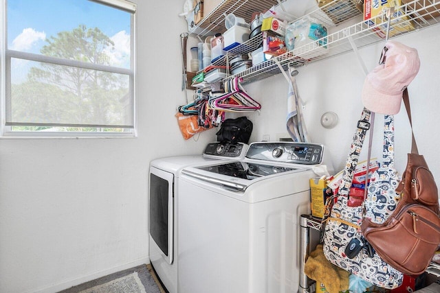 clothes washing area with baseboards, laundry area, and separate washer and dryer
