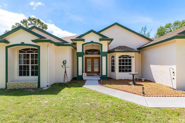 single story home with french doors, a front yard, and stucco siding