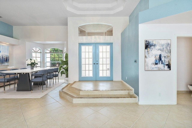 entryway with a healthy amount of sunlight, tile patterned floors, and french doors