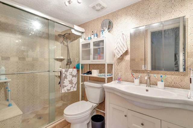 full bath with vanity, toilet, a shower stall, visible vents, and tile walls