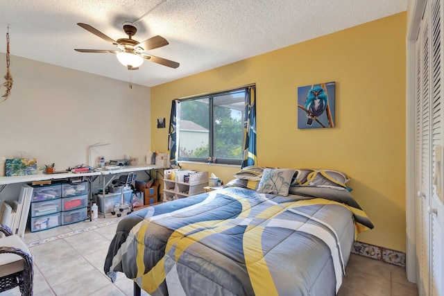 bedroom with a closet, a textured ceiling, a ceiling fan, and light tile patterned flooring