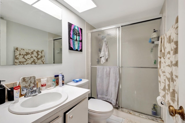 full bath featuring toilet, vanity, a stall shower, and a skylight