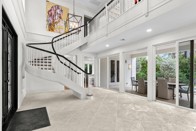 5 Osprey Ct, Ocean Ridge, FL 33435 - foyer featuring a chandelier, stairs, plenty of natural light, a high ceiling, and ornamental molding