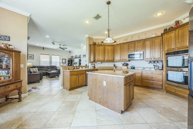 694 Cresta Cir, West Palm Beach, FL 33413 - kitchen featuring a peninsula, open floor plan, appliances with stainless steel finishes, brown cabinetry, and ornamental molding