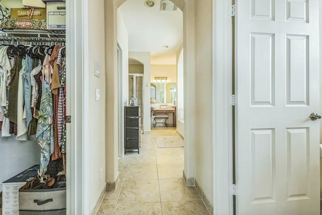 694 Cresta Cir, West Palm Beach, FL 33413 - hallway featuring arched walkways, visible vents, baseboards, and light tile patterned flooring
