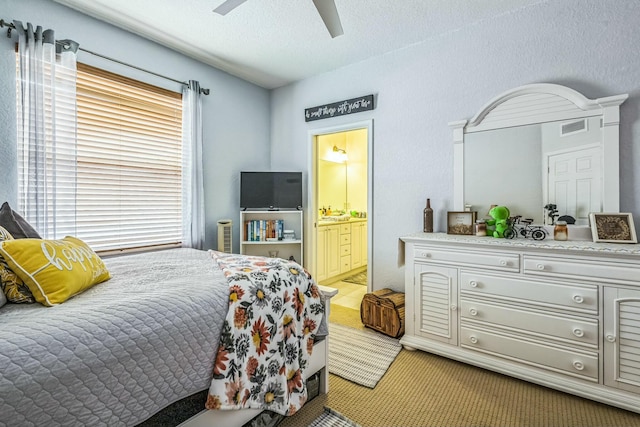 694 Cresta Cir, West Palm Beach, FL 33413 - bedroom with a textured ceiling, visible vents, light colored carpet, ceiling fan, and ensuite bath