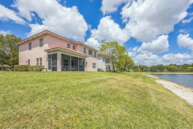 694 Cresta Cir, West Palm Beach, FL 33413 - back of property featuring a tiled roof, a yard, a water view, stucco siding, and a sunroom