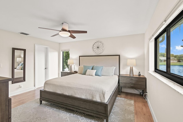 bedroom featuring visible vents, baseboards, and wood finished floors