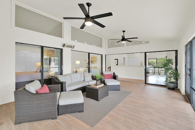 living room featuring a ceiling fan, vaulted ceiling, and wood finished floors