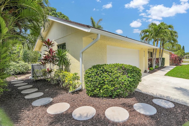 6125 Winding Brook Way, Delray Beach, FL 33484 - view of property exterior with an attached garage, stucco siding, and cooling unit